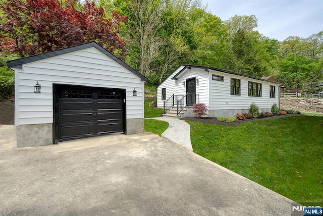 view of front of house with an outbuilding, a front yard, and a garage