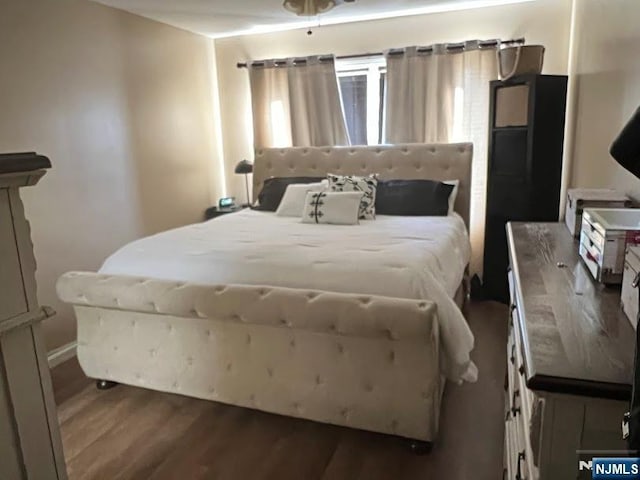 bedroom with dark hardwood / wood-style flooring