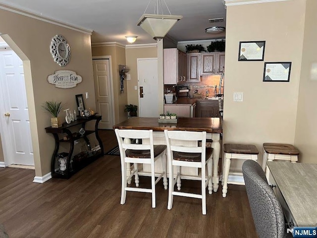 dining space with ornamental molding and dark wood-type flooring