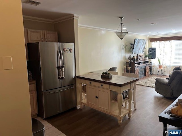 kitchen featuring kitchen peninsula, crown molding, stainless steel refrigerator, and tile countertops