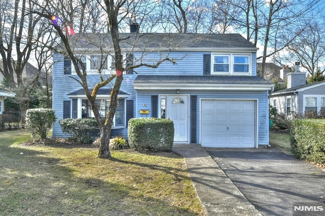 view of front facade featuring driveway, a front lawn, and an attached garage