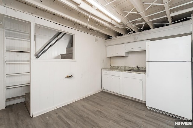 kitchen featuring dark hardwood / wood-style flooring, sink, white fridge, and white cabinets