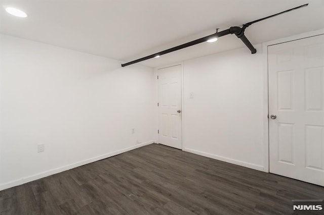 unfurnished room with dark wood-type flooring