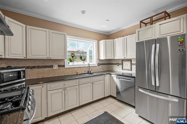 kitchen featuring appliances with stainless steel finishes, dark stone counters, white cabinets, light tile patterned floors, and sink