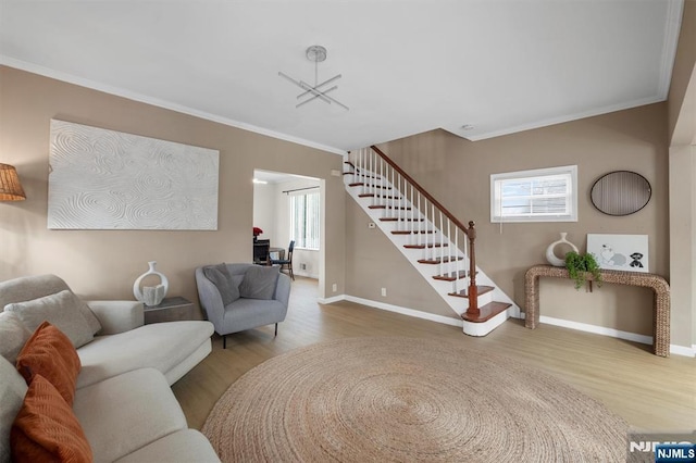 living room with wood-type flooring, a wealth of natural light, and crown molding