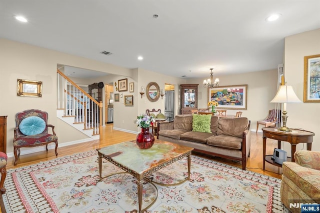 living room with visible vents, stairway, an inviting chandelier, light wood-type flooring, and recessed lighting