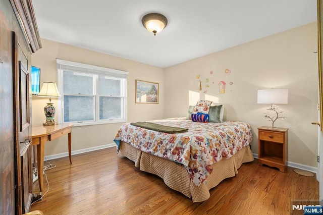 bedroom with baseboards and wood finished floors