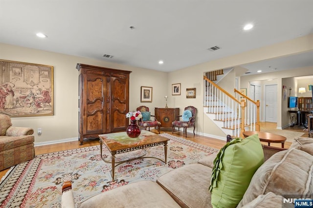 living room featuring light wood-style floors, stairs, visible vents, and recessed lighting