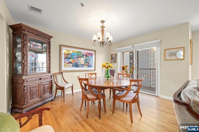 dining room with an inviting chandelier, light wood-style flooring, visible vents, and baseboards