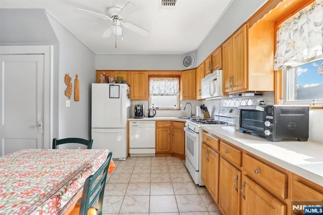 kitchen featuring white appliances, a sink, visible vents, light countertops, and backsplash