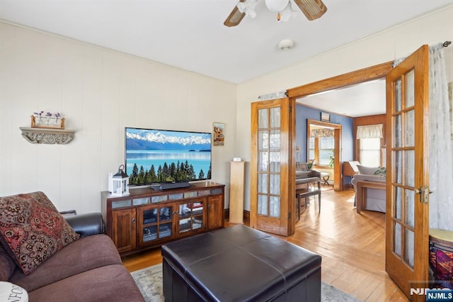 living area featuring a ceiling fan and french doors