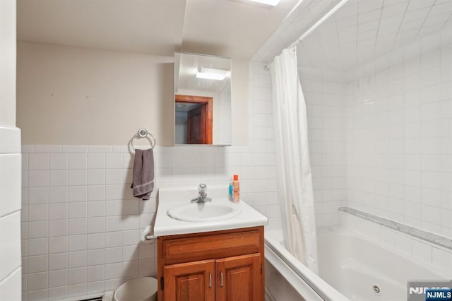 bathroom with shower / tub combo, vanity, and tile walls