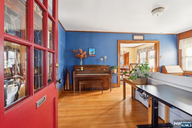 living area with ornamental molding and wood finished floors