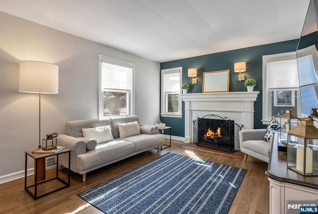 living room featuring a brick fireplace and dark hardwood / wood-style flooring