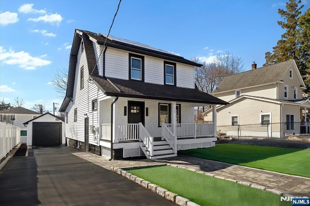 view of front of house with an outbuilding, a porch, aphalt driveway, a garage, and fence