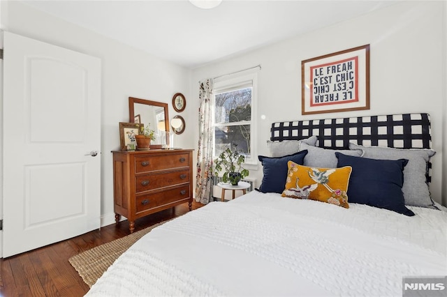 bedroom with dark wood-type flooring