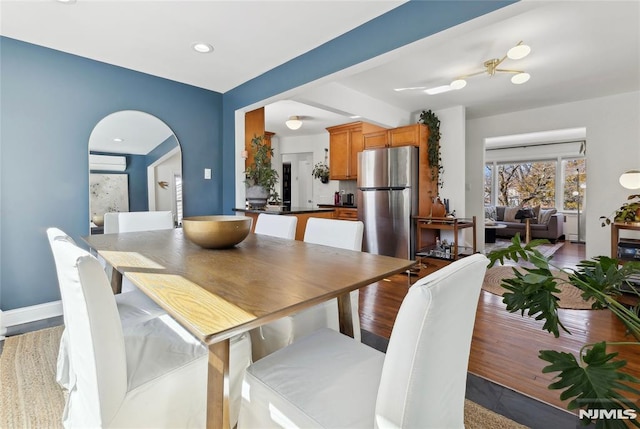 dining space featuring a wall mounted AC and light hardwood / wood-style flooring