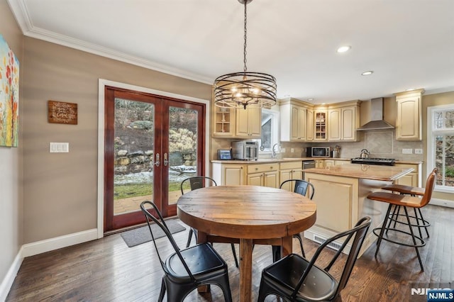 dining room featuring ornamental molding, french doors, dark wood-type flooring, and baseboards