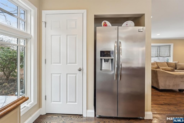 kitchen featuring baseboards, stainless steel refrigerator with ice dispenser, and dark wood-type flooring