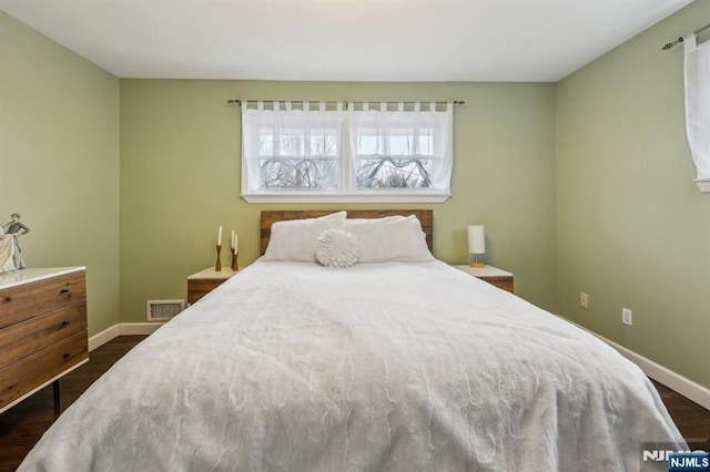 bedroom with dark wood-type flooring, visible vents, and baseboards