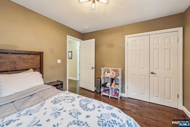 bedroom with a closet, baseboards, and wood finished floors