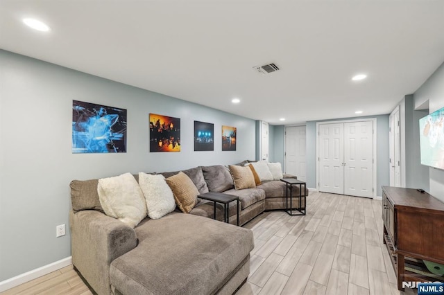 living room featuring light wood finished floors, baseboards, visible vents, and recessed lighting