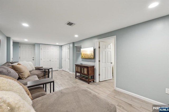 living room with baseboards, recessed lighting, visible vents, and light wood-style floors