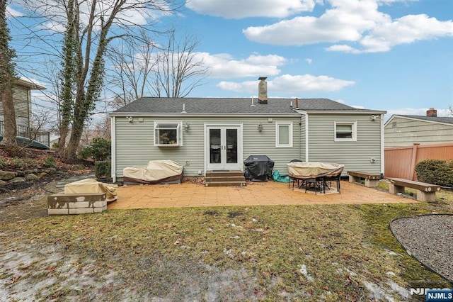 back of property with entry steps, a lawn, a patio, and french doors