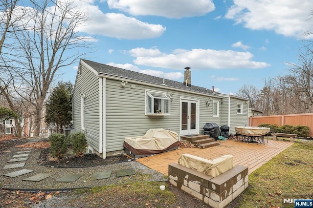 back of property with french doors, a patio area, fence, and a chimney