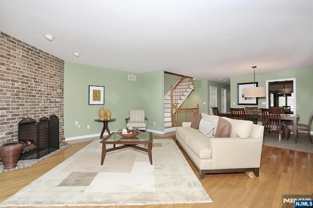 living room featuring light wood-type flooring and a fireplace