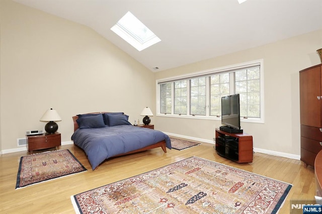 bedroom featuring hardwood / wood-style floors and lofted ceiling with skylight