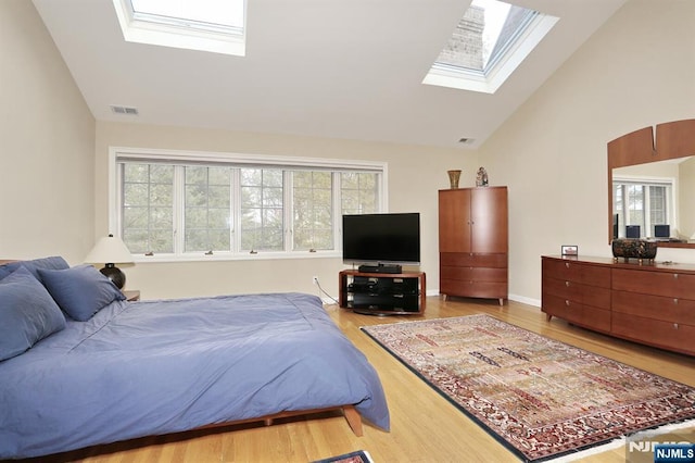 bedroom featuring multiple windows, wood-type flooring, and a skylight