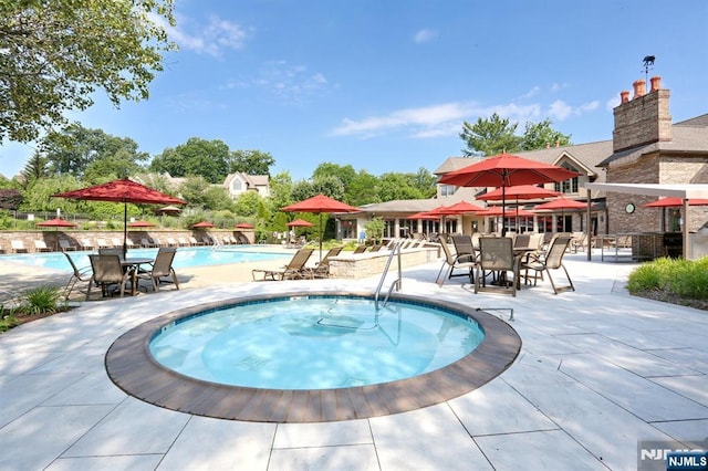 view of pool with a patio area and a community hot tub