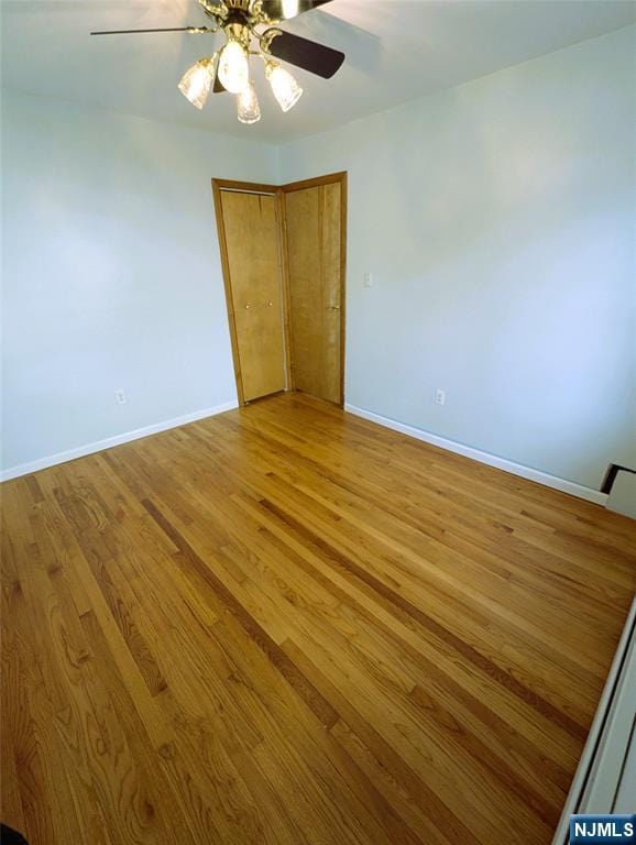 unfurnished room with light wood-style floors, baseboards, and a ceiling fan