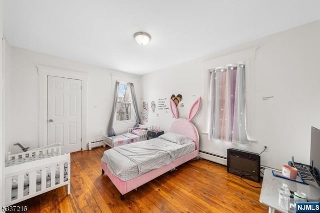 bedroom featuring hardwood / wood-style flooring and a baseboard radiator