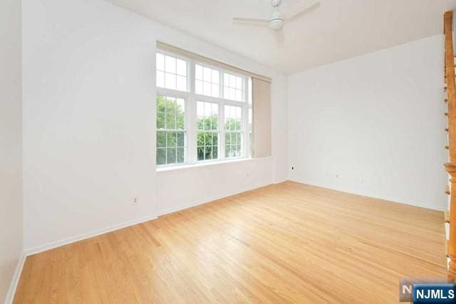 spare room with ceiling fan and wood finished floors