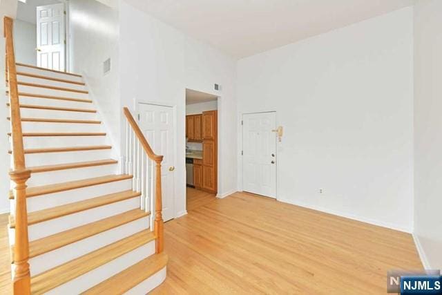 foyer featuring stairway, visible vents, and light wood-style floors