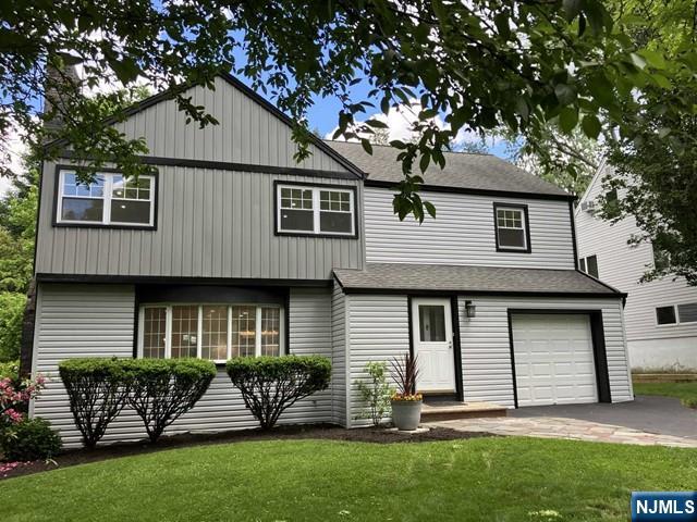 view of front of home with a garage and a front lawn