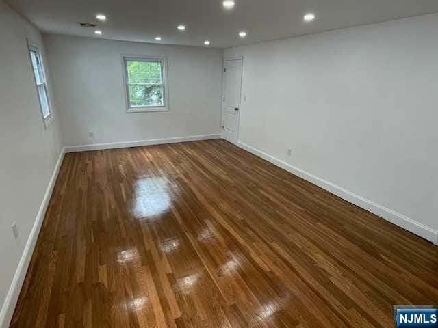 empty room with dark hardwood / wood-style flooring