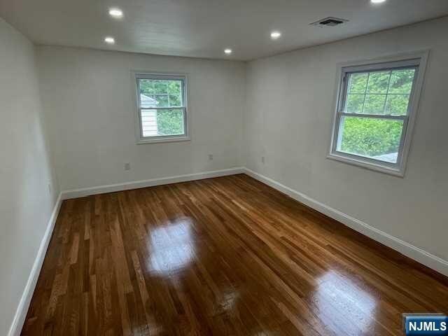 empty room with dark hardwood / wood-style floors