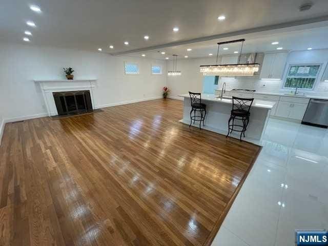 unfurnished living room featuring sink and wood-type flooring