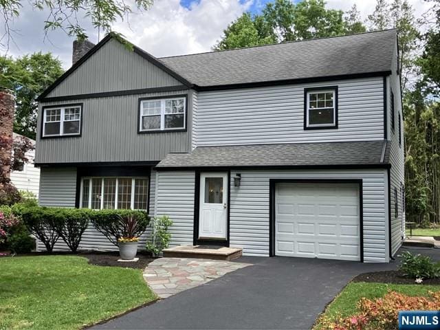 view of front facade with a garage and a front lawn