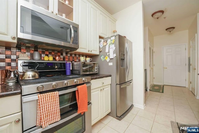 kitchen with white cabinetry, stainless steel appliances, and light tile patterned flooring