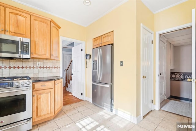 kitchen featuring crown molding, light tile patterned floors, tasteful backsplash, appliances with stainless steel finishes, and light brown cabinets