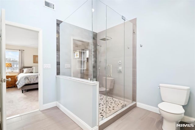 full bath featuring a stall shower, baseboards, visible vents, toilet, and ensuite bathroom