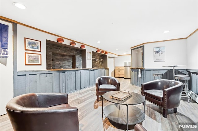 interior space featuring light wood-style floors, ornamental molding, bar area, and recessed lighting