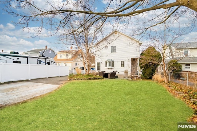 back of house with a lawn and fence