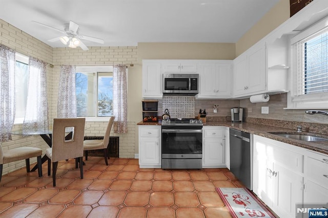 kitchen with white cabinets, appliances with stainless steel finishes, sink, and a wealth of natural light