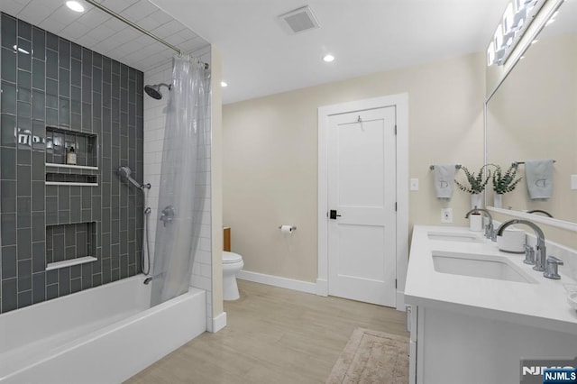 full bathroom featuring toilet, hardwood / wood-style flooring, vanity, and shower / tub combo