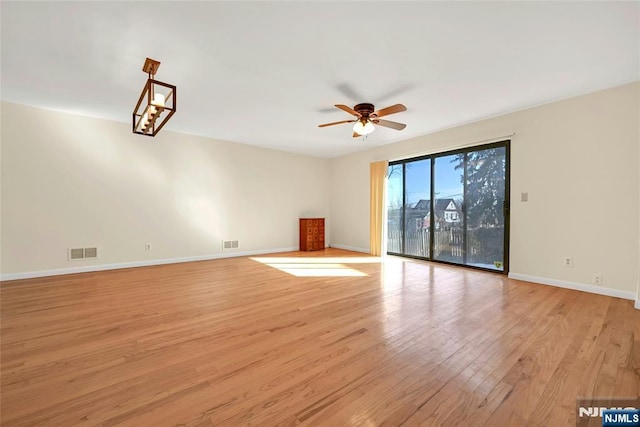 unfurnished living room with baseboards, a ceiling fan, visible vents, and light wood-style floors